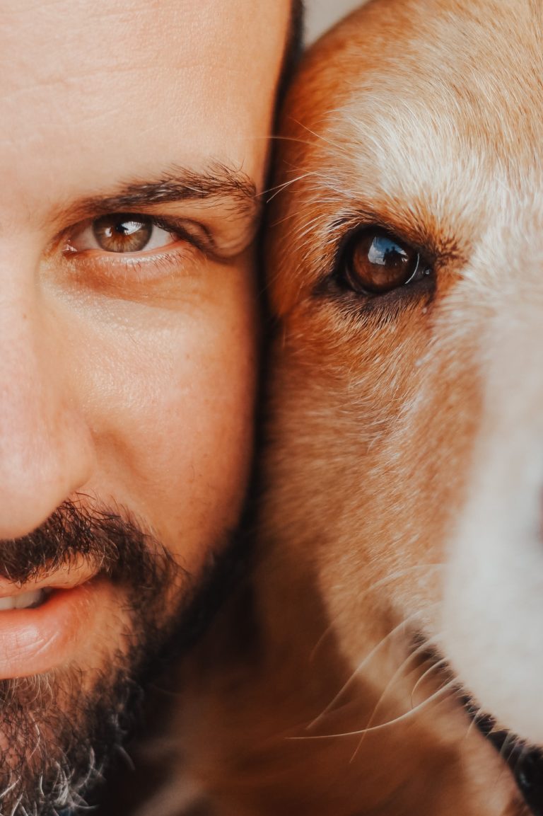 Man and dog faces next to each other both smiling